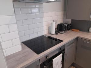a kitchen with a sink and a counter top at Chorlton Apartments in Sale