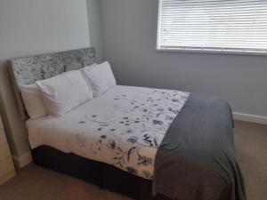 - une chambre avec un lit dans une pièce dotée d'une fenêtre dans l'établissement Chorlton Apartments, à Sale