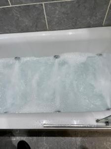 eine Badewanne mit einem mit Wasser bedeckten Fenster in der Unterkunft Paul Properties in Ruislip