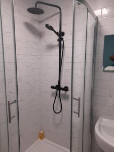 a shower with a shower head in a bathroom at Chorlton Apartments in Sale