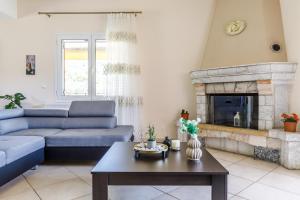 a living room with a blue couch and a fireplace at Eleonora's in Skopelos Town