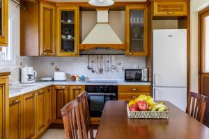 a kitchen with wooden cabinets and a table with fruit on it at Eleonora's in Skopelos Town