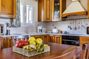 a kitchen with a table with a basket of fruit at Eleonora's in Skopelos Town