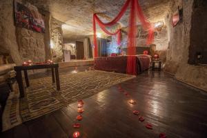 una stanza con un tavolo e candele rosse sul pavimento di Kapadokya Ihlara Konakları Otel Konak Odaları a Guzelyurt