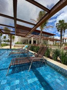 three chairs sitting in a pool in a resort at Resort Quinta Santa Bárbara in Pirenópolis