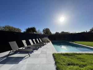 una fila de sillas sentadas junto a una piscina en Bigaro II en Heers