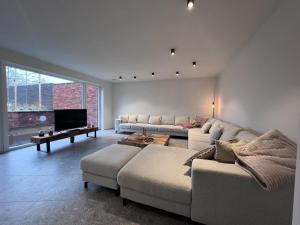 uma sala de estar com um sofá e uma televisão em Bigaro II em Heers