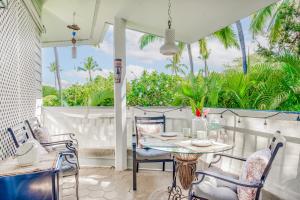 d'une terrasse avec une table, des chaises et des palmiers. dans l'établissement Keauhou Paradise at Mauna Loa Village #10, à Kailua-Kona