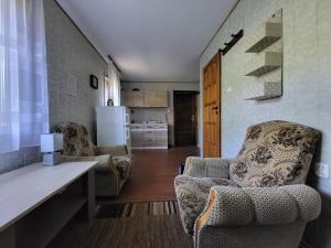 uma sala de estar com 2 cadeiras e um frigorífico em Agroturystyka Pod Lipą em Małe Leżno