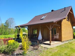uma pequena cabina de madeira com um telhado inclinado em Agroturystyka Pod Lipą em Małe Leżno