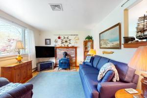 - un salon avec un canapé bleu et une cheminée dans l'établissement Hyannis Beach House, à Hyannis