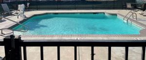 a large swimming pool with blue water at Budget Inn Alexandria in Alexandria