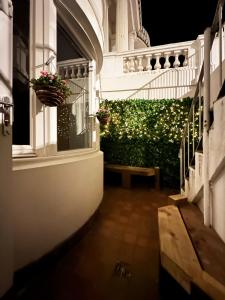 a balcony with a bench and a hedge with lights at Liam's Place near Hyde Park in London