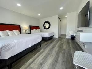 um quarto de hotel com duas camas e um lavatório em Budget Inn em Lompoc