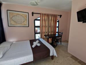 a bedroom with a bed and a table and a window at Hotel Colonial San Carlos in Cancún