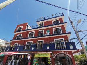 un edificio rojo alto con una tienda delante en Hotel Colonial San Carlos en Cancún