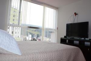 a bedroom with a bed and a flat screen tv at Suite La Colina - Norte - Pasto in Pasto
