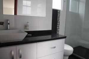 a white bathroom with a sink and a toilet at Suite La Colina - Norte - Pasto in Pasto