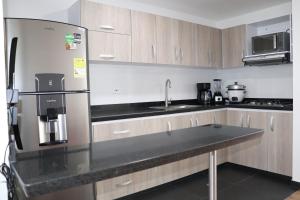 a kitchen with a stainless steel refrigerator and cabinets at Suite La Colina - Norte - Pasto in Pasto
