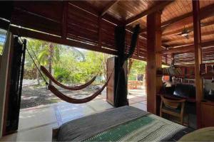 sypialnia z hamakiem wiszącym na oknie w obiekcie Private NEW beach house with garden w mieście Cabuya
