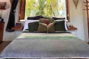 1 dormitorio con 1 cama grande con almohadas verdes en Private NEW beach house with garden, en Cabuya