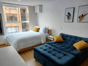 sala de estar con sofá azul y cama en Splendid Loft in Chapinero en Bogotá