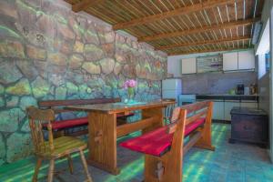 eine Küche mit einem Tisch, Stühlen und einer Steinmauer in der Unterkunft Family friendly house with a swimming pool Vadalj, Primosten - 21379 in Vadalj