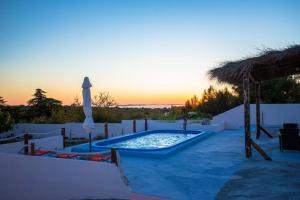 einen Pool mit Sonnenschirm und Sonnenuntergang im Hintergrund in der Unterkunft Family friendly house with a swimming pool Vadalj, Primosten - 21379 in Vadalj