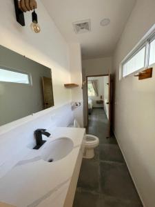 a bathroom with a sink and a toilet at Casa Mariposa in Tola