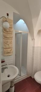 bagno bianco con doccia e lavandino di Barocco Art House a Martina Franca