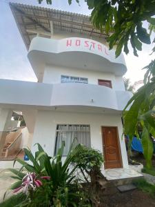 un edificio blanco con un cartel. en Hostal Brisas Del Mar, en Puerto Villamil