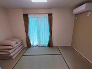 um quarto vazio com uma janela com cortinas em FunHome黒川 em Nagoia