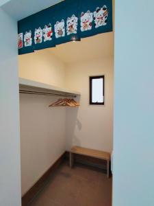 Zimmer mit einem Regal und einer Bank unter einer Decke in der Unterkunft FunHome黒川 in Nagoya