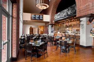 um restaurante com mesas e cadeiras e um bar em Sheraton Raleigh Hotel em Raleigh