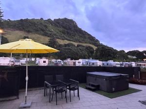 a patio with a table and chairs and an umbrella at The Bay The Beach The Mount The Best in Mount Maunganui