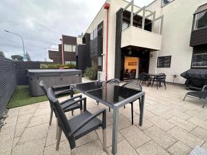 a patio with a table and chairs and a building at The Bay The Beach The Mount The Best in Mount Maunganui