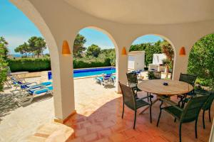 モライラにあるMimosa - pretty holiday property with private pool in Morairaのパティオ(テーブル、椅子付)、プールが備わります。