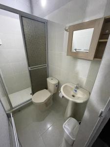 een witte badkamer met een toilet en een wastafel bij villa vale Rivera Huila in Rivera