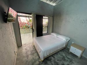 1 dormitorio con cama blanca y ventana en villa vale Rivera Huila en Rivera
