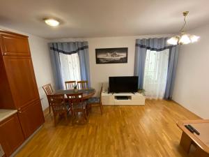 een woonkamer met een tafel en een televisie bij Shadi Apartment in Koper