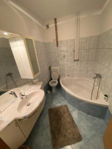 een badkamer met een bad, een wastafel en een toilet bij Shadi Apartment in Koper