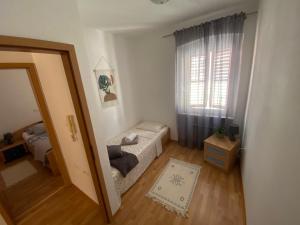 een kleine woonkamer met een raam en een bank bij Shadi Apartment in Koper