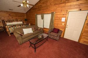 a living room with a couch and a chair and a bed at Cabin Close to parkway rd with River View in Pigeon Forge