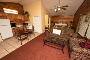 a living room with a couch and a table and a kitchen at Cabin Close to parkway rd with River View in Pigeon Forge