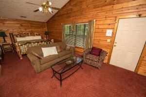 a living room with a couch and chairs in a cabin at Cabin Close to parkway rd with River View in Pigeon Forge