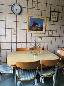 a dining room table with chairs and a clock on the wall at A Casa da Playa do Con - Moaña in Moaña
