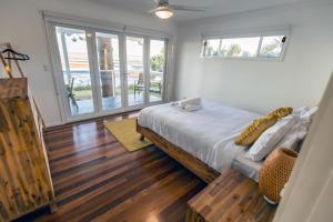 a bedroom with a bed and a large window at Happy Tides in Beachmere