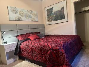 a bedroom with a bed with a red comforter at Bel apartment in Sioux City