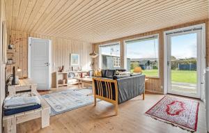 een woonkamer met een bureau en een kamer met ramen bij Nice Home In Juelsminde With Kitchen in Sønderby