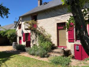 una casa antigua con persianas rojas en Grande maison familiale, rustique et charmante en Bourgogne, dans le Morvan, en Dun-sur-Grandry